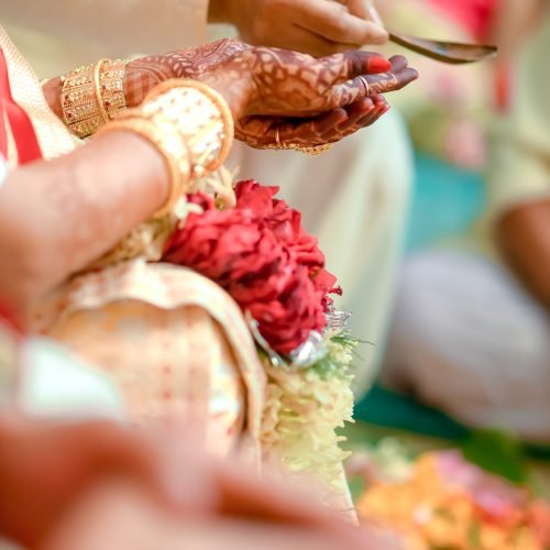 A vertical closeup shot of a Hindu bride's hands with henna during a traditional wedding